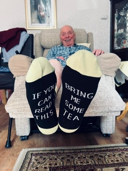 close up shot of a pair of socks which say if you can read this bring me some tea on the soles