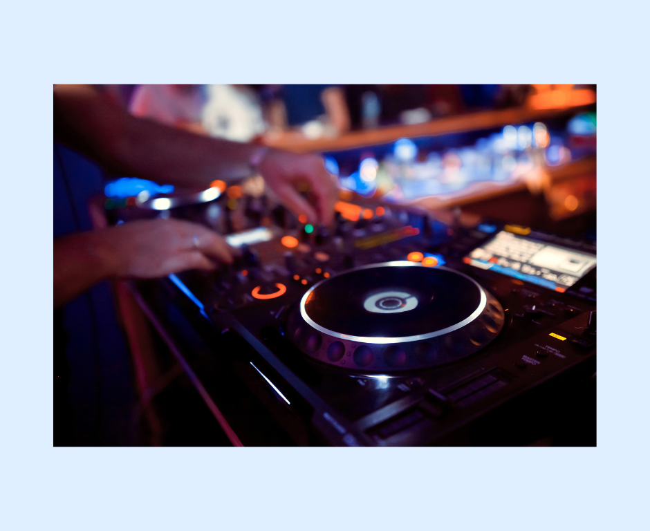 DJ playing on DJ decks in a nightclub