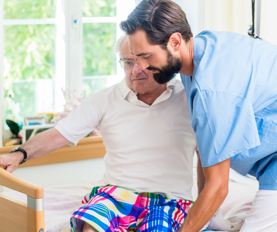 male health worker assists older man to move to the edge of the bed