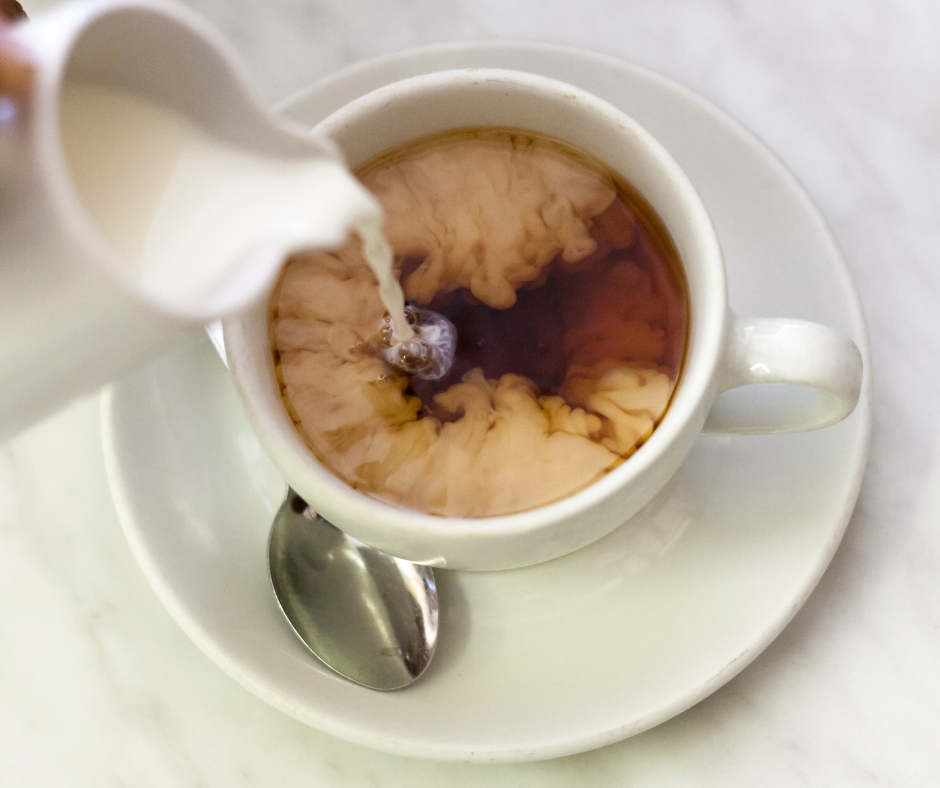 milk pouring into a cup of coffee