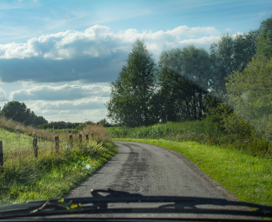 view of a country road seen through a windscreen