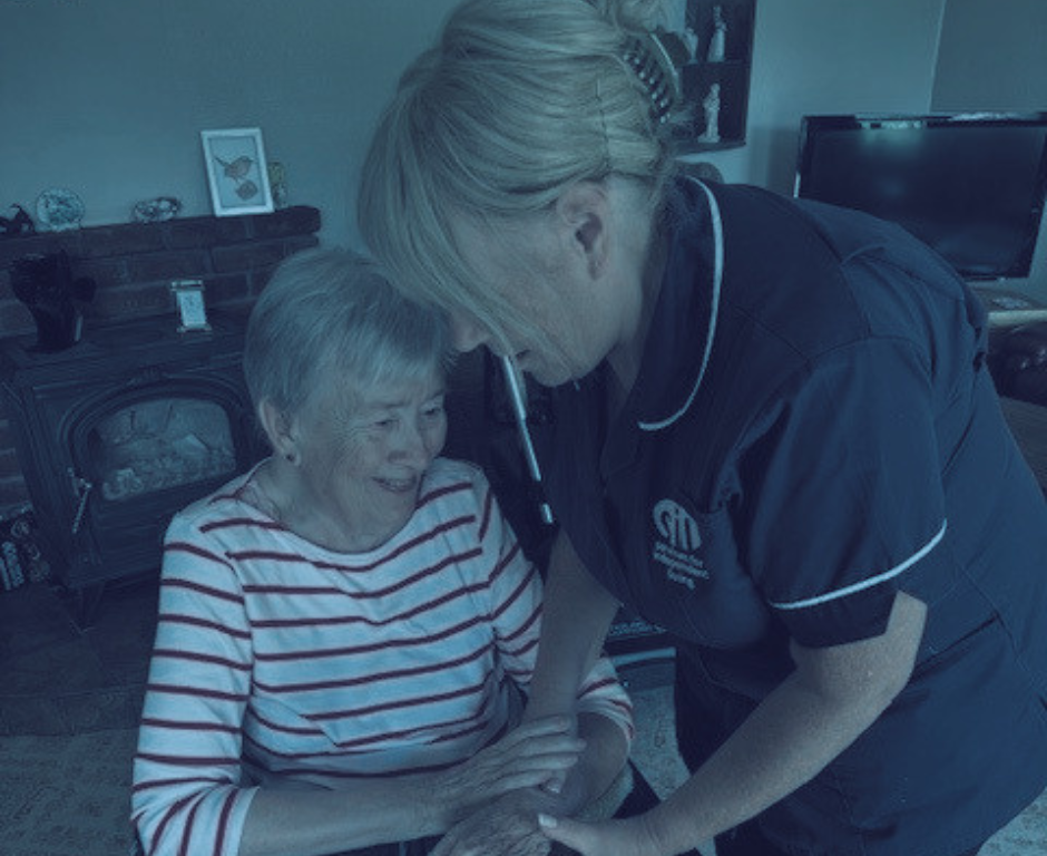 Homecare worker from Services for Independent Living attends to a woman seated in a chair
