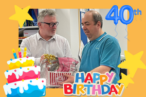 Euan Macpherson, SiL's Chief Executive hands Tim a birthday card and gift hamper